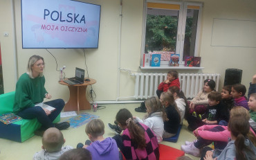Uczniowie słuchają, bibliotekarki która opowiada o polskich symbolach narodowych