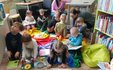 Dzieci oglądają książki siedząc na podłodze