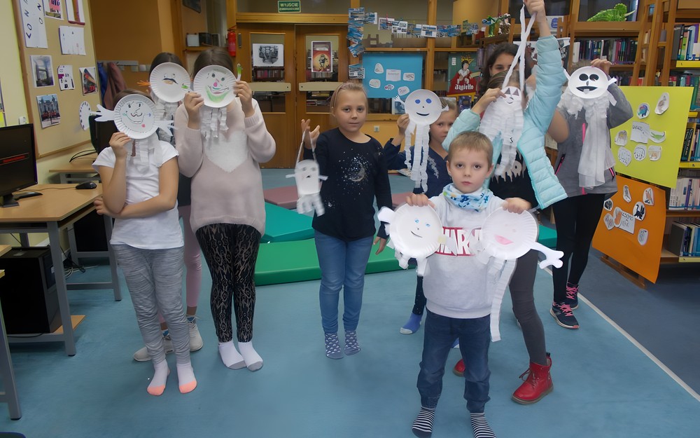 Dzieci pozują do zdjęcia z wykonanymi przez siebie duszkami