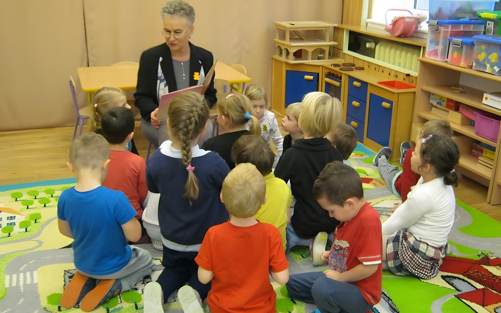 bibliotekarz głośno czyta książkę dzieciom