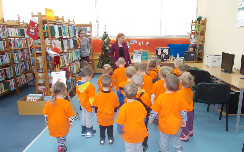 Dzieci stoją przedc bibliotekarką i nasladują jej ruchy