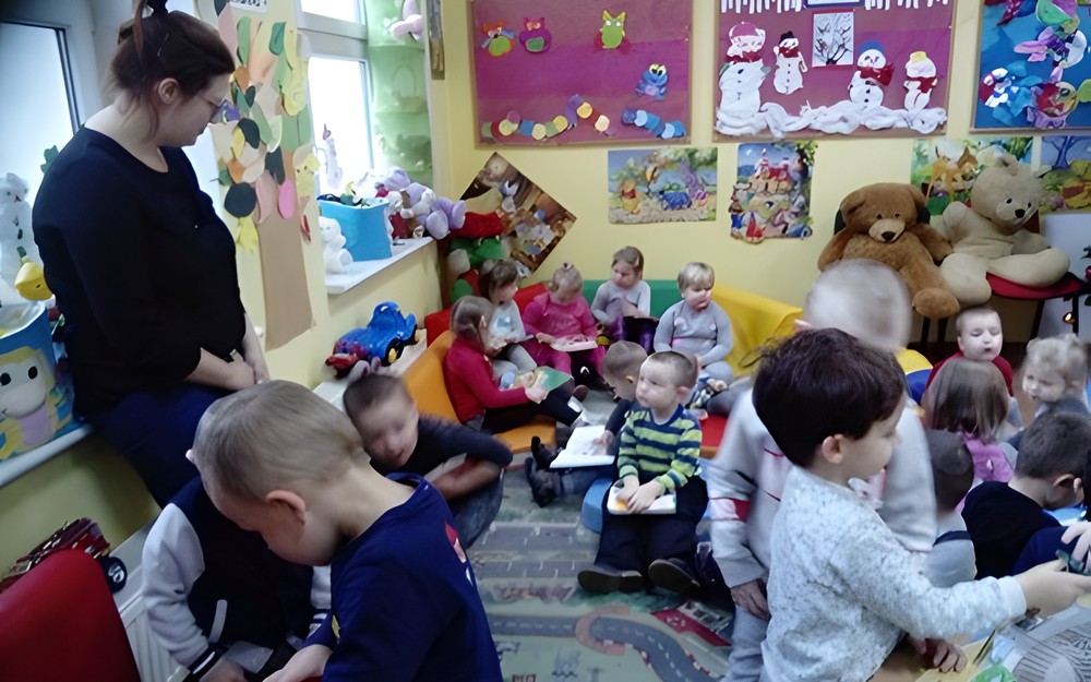 Dzieci siedza na dywanie i przeglądają książki