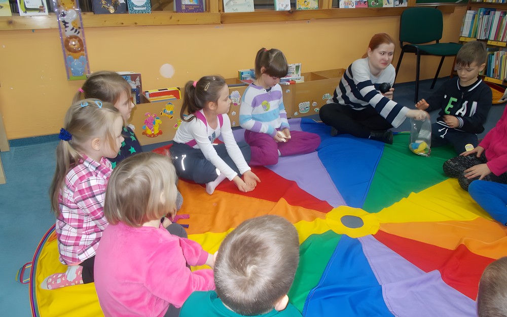 Bibliotekarka tłumaczy dzieciom zasady gry