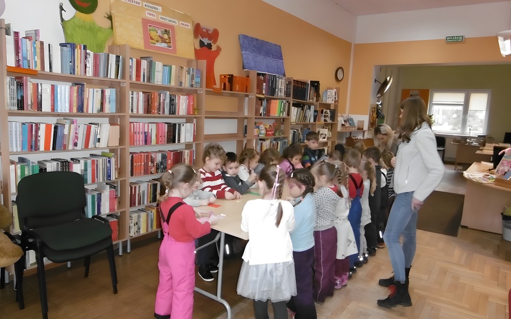 Dzieci przy stole pracują nad swoimi zadaniami.