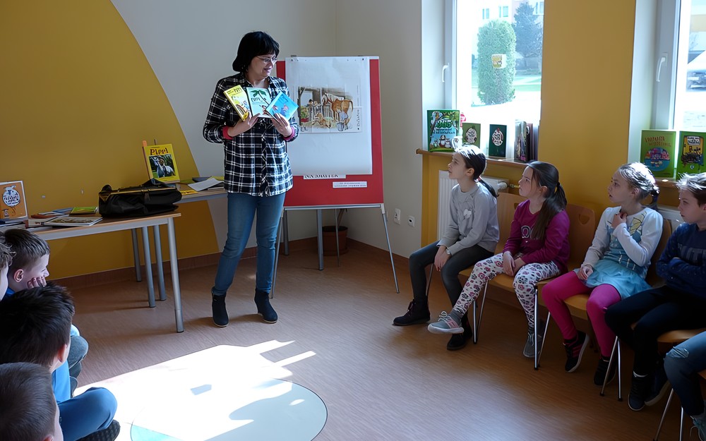 Pani Wiola wyjmuje z kufra i prezentuje najbardziej znane książki Astrid Lindgren