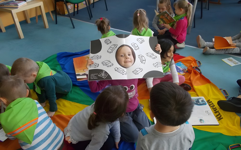 dziewczynka pozuje do zdjęcia z książką