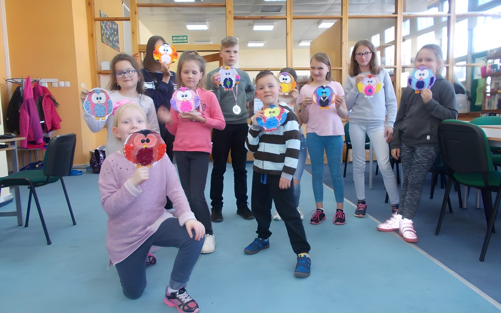 Dzieci pozują do zdjęcia ze swoimi pracami