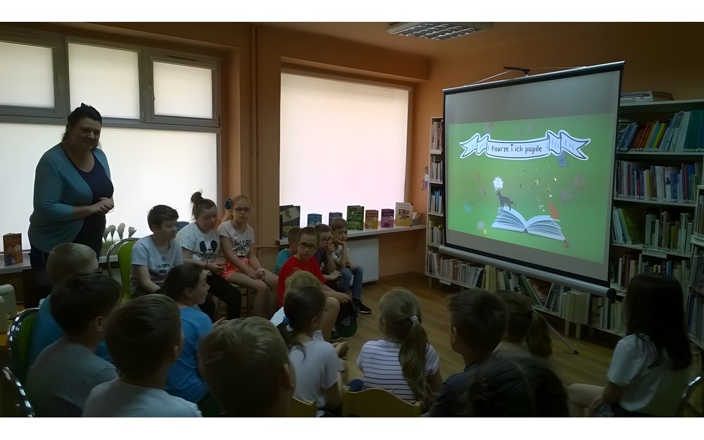 Bibliotekarka Ania rozpoczyna spotkanie, dzieci siedzą na krzesełkach