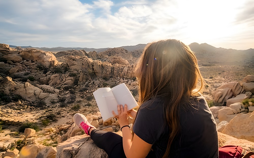 Natolatka czytająca książkę w plenerze górskim
