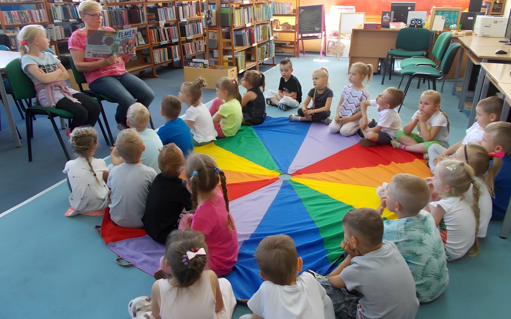 Zaproszony gość czyta dzieciom książkę pt. "Elmer"