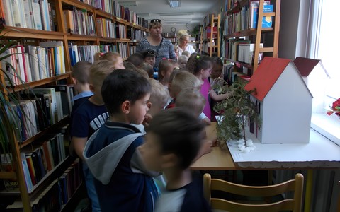 Grupa przedszkolaków przy makiecie "Domek Kata"