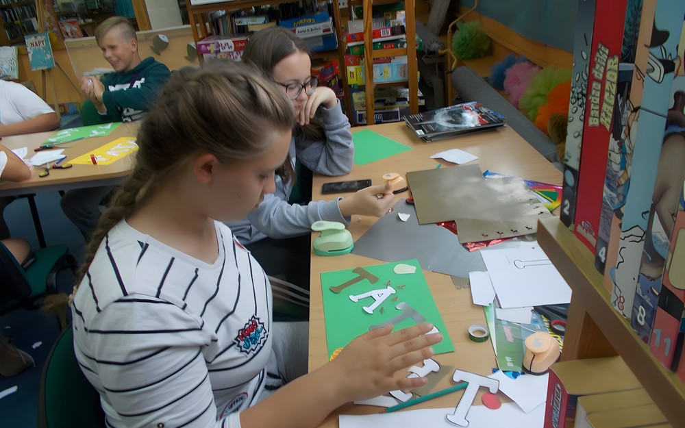 Dwie dziewczynki wykonują laurkę dla taty