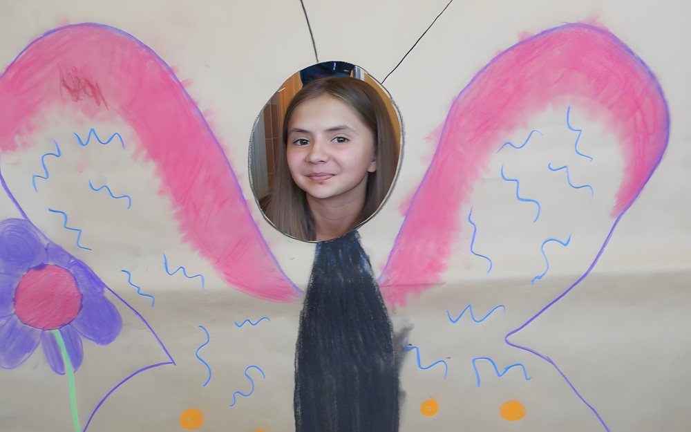 Dziewczynka pozuje do zdjęcia z makietą