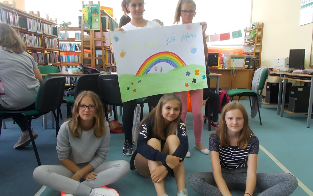 Dziewczynki pozują z samodzielnie wykonanym plakatem