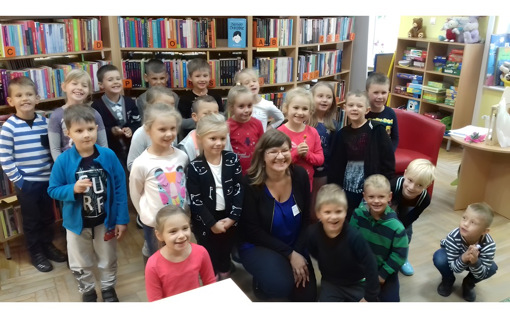 Dzieci i bibliotekarka pozują do zdjęcia.