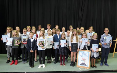 Wspólne zdjęcie uczestników Powiatowego konkursu Mistrzowie Pięknego Czytania 2018. Dzieci trzymają zdobyte przez siebie dyplomy.