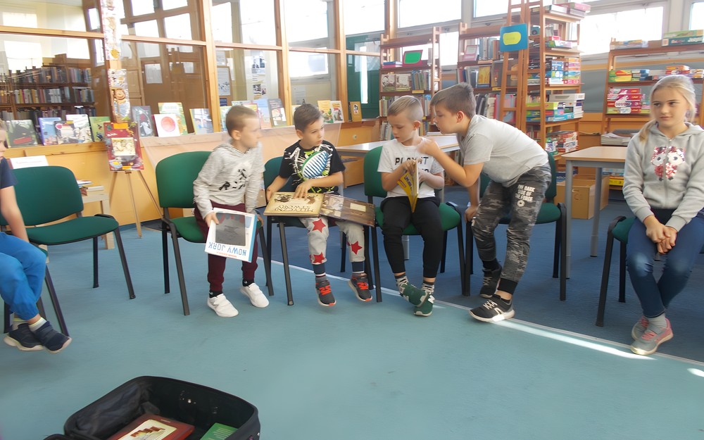 Chłopcy oglądają książki i wymieniają się poglądami