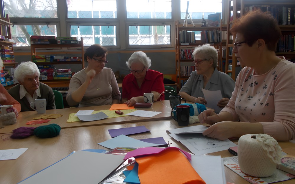 Panie przy stole planują wykonywanie kukiełek