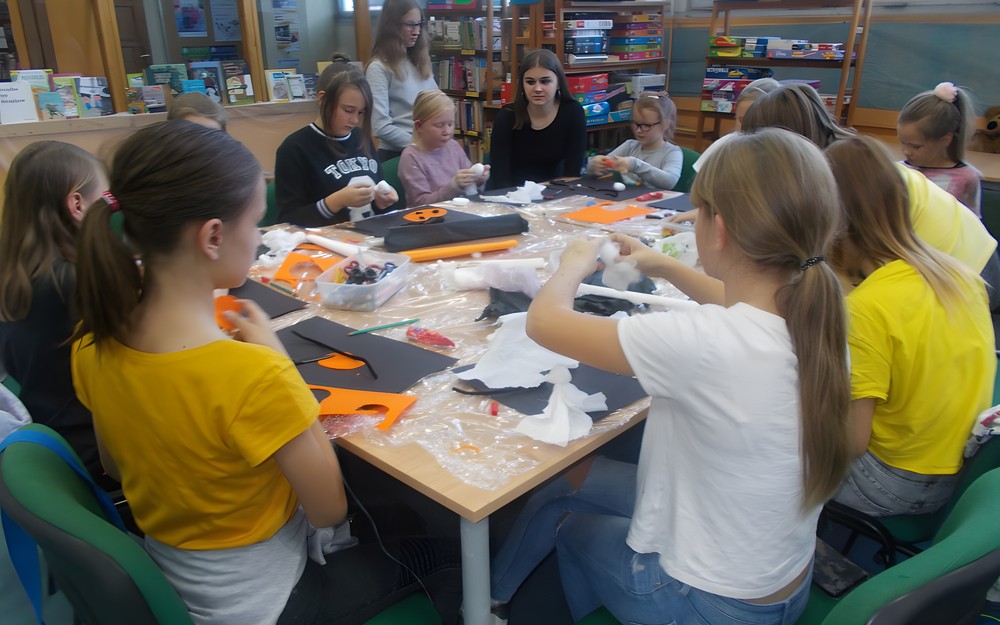 Dzieci pracują przy wspólnym stole tworząc prace plastyczne