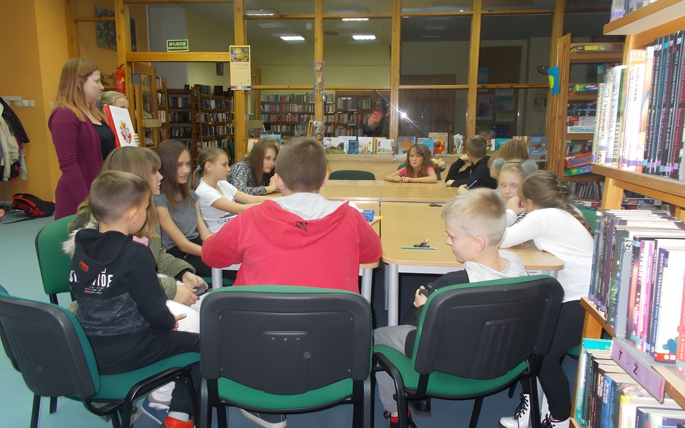 Bibliotekarka rozmawia o symbolach narodowych i pokazuje dzieciom literaturę