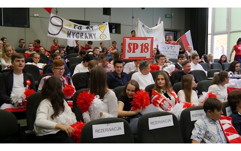 Kibicujmy Polsce: zdjęcie zrobione podczas  Turnieju Wiedzy o życiu literackim Dwudziestolecia międzywojennego. Uczniowie drużyn biorących udział w turnieju, przebrani w barwy narodowe Polski , kibicują swoim.