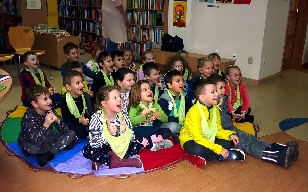 Przedszkolaki - bardzo żywiołowa grupa - siedzą na chuście integracyjnej i powtarzają formułę powitania CZEŚĆ, HEJ OK!