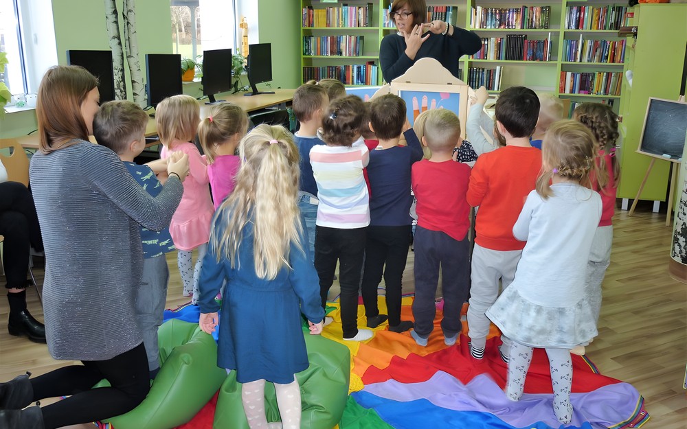 Dzieci z zaciekawieniem słuchają opowieści o pięciu paluszkach