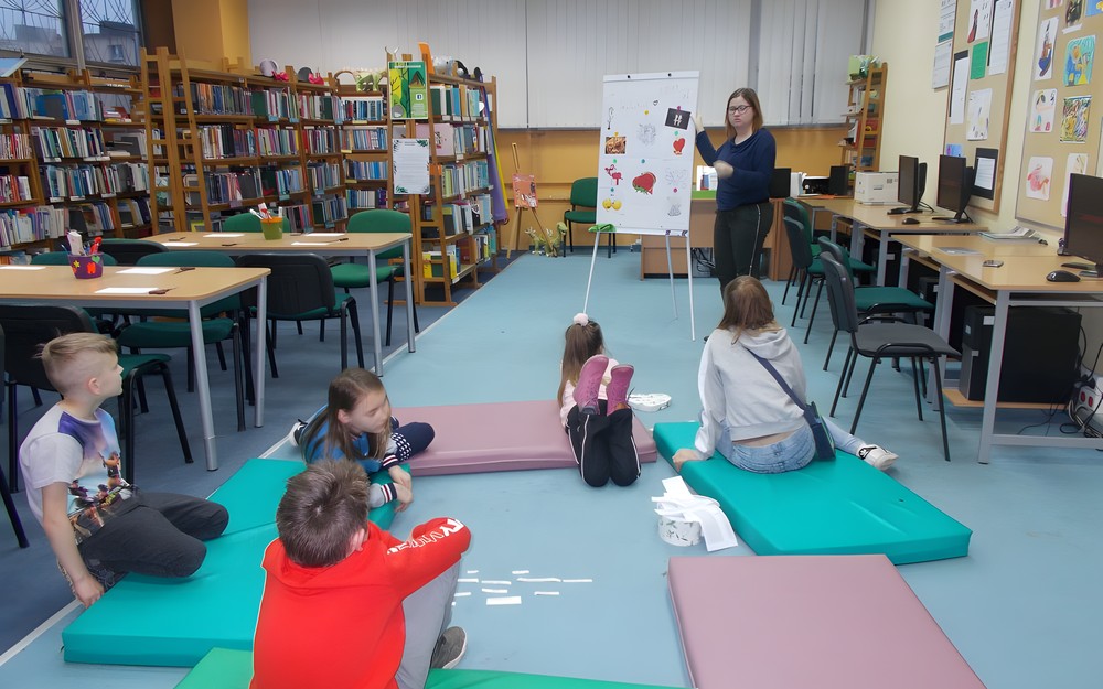 Bibliotekarka stoi przy tablicy flipart i tlumaczy angielskie odpowiedniki słów kojarzące się z walentynkami