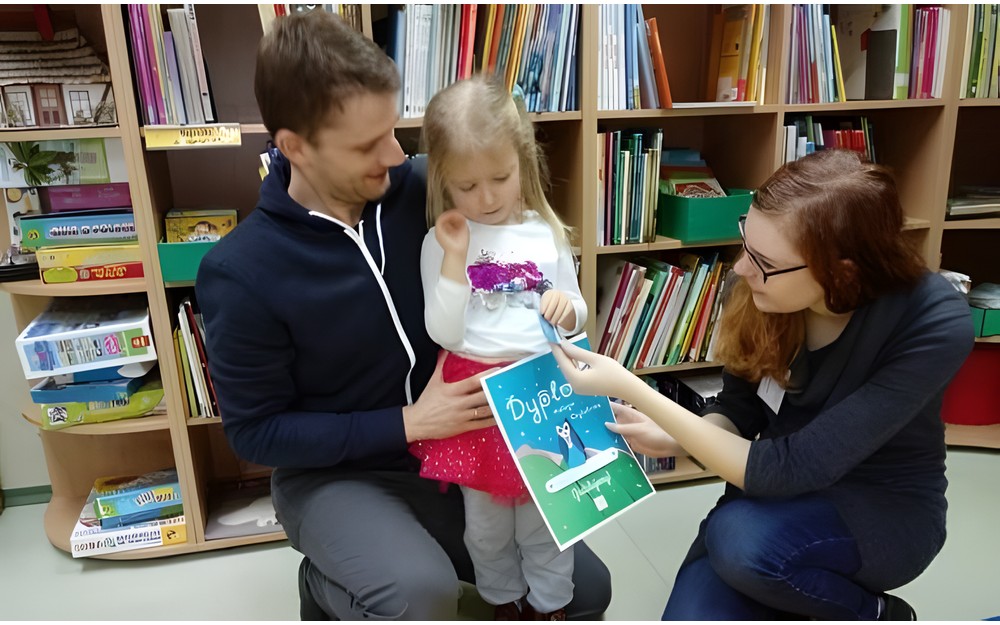 Mała Czytelniczka otrzymuje dyplom od bibliotekarki