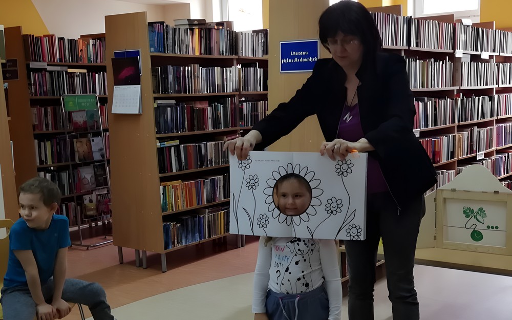 Bibliotekarka wraz z przedszkolakiem prezentuje KSIĄŻKĘ Z DZIURĄ