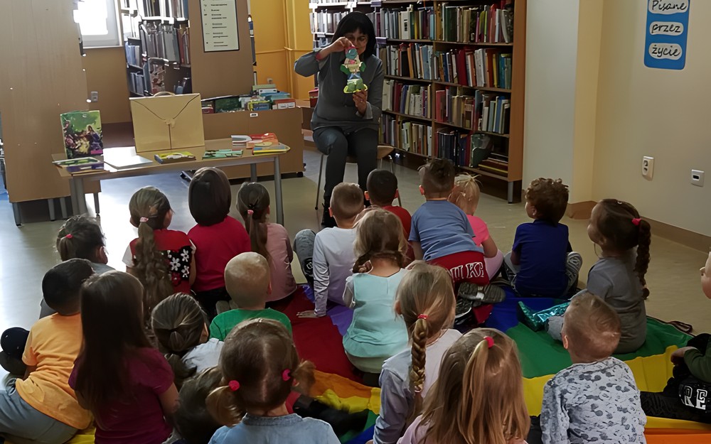 Bibliotekarka prezentuje przedszkolakom najciekawsze książeczki dla najmłodszych