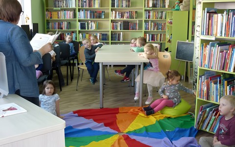 Bibliotekarka czyta dzieciom książkę "Kamyczek w bibliotece"
