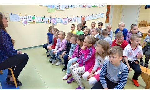 Dzieci słuchają czytanej ksiażki.