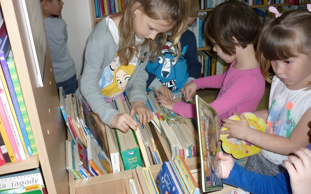 Dzieci przeglądają BIBLIOTECZKĘ MALUCHA