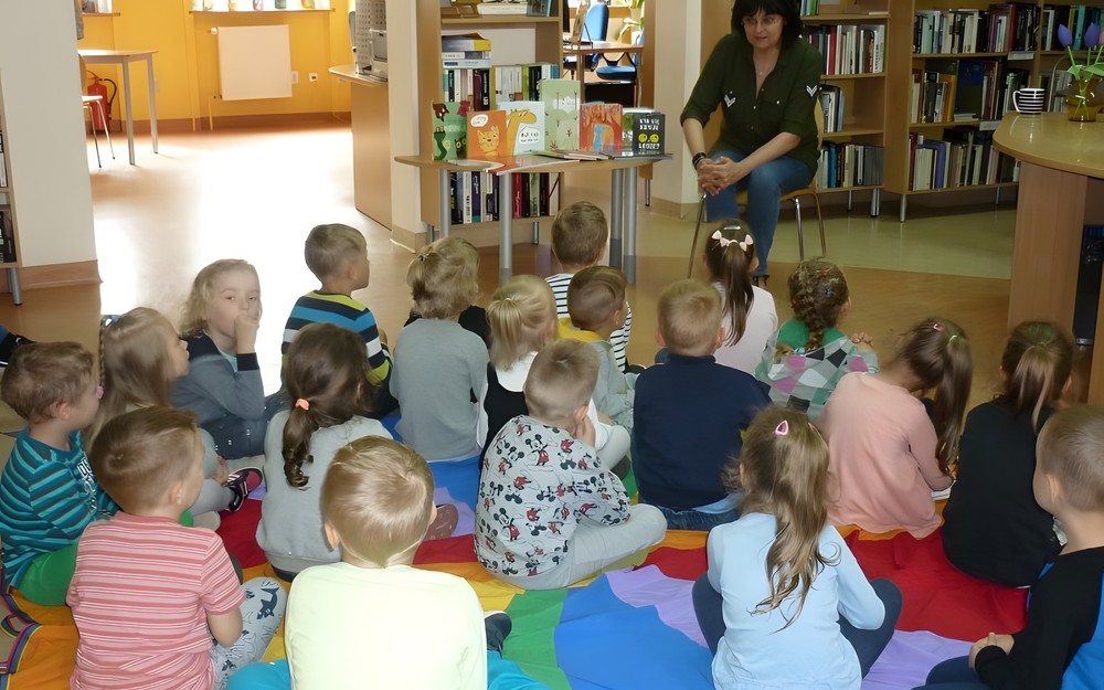 Dzieci siedzą na chuście integracyjnej - rozpoczynamy spotkanie.