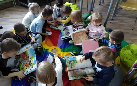 Grupa dzieci ogląda książki