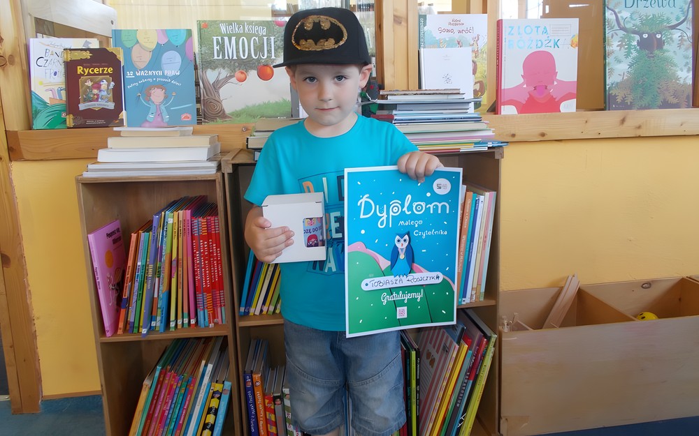 Chłopiec pozuje ze zdobytym dyplomem