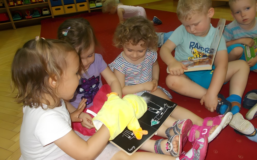 Dzieci oglądają książeczki i pacynki
