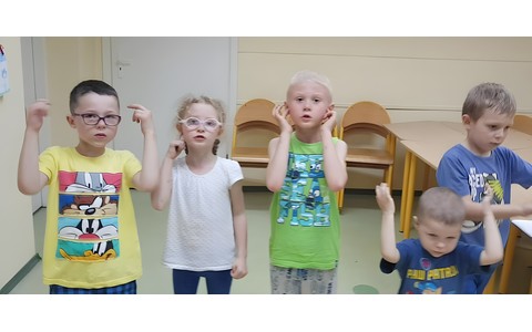 Dzieci śpiewają piosenkę i tańczą.