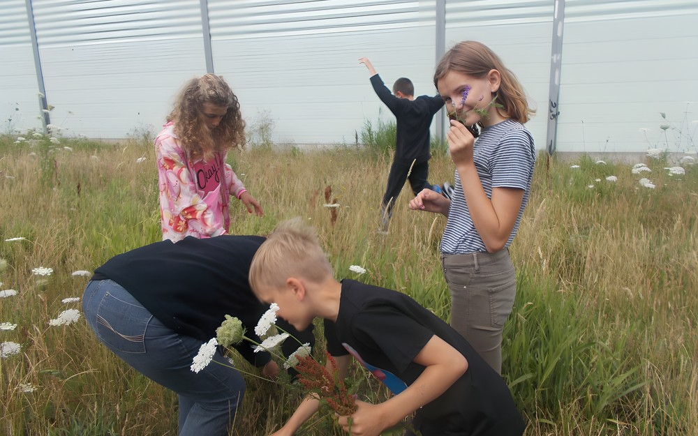 Dzieci zbierają kwiaty na łące