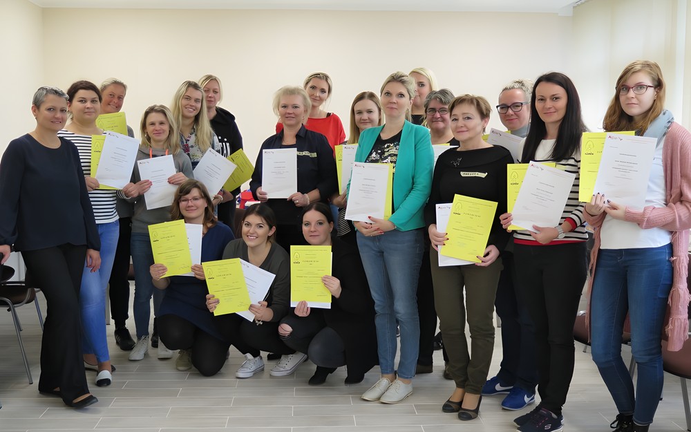 Uczestniczki warsztatów stoją z trenerką na wspólnym zdjęciu