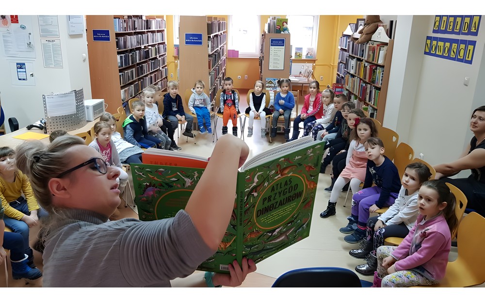 Pani Małgosia prezentuje książki o dinozaurach
