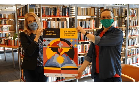Plakat promujący Tydzień Bibliotek 2020 trzymają od lewej: Z-ca dyrektora KBP, Beata Sawa-Jovanoska oraz dyrektor KBP, Dariusz Pawlikowski