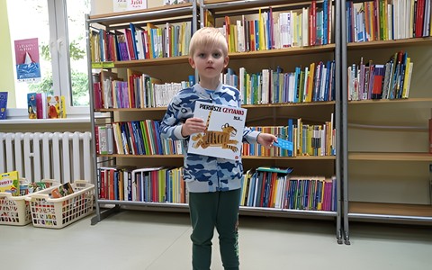 Nowy czytelnik trzymający książeczkę oraz kartę.