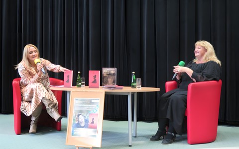 Od lewej: Prowadząca spotkanie Alicja Balcerzak, Adela Kuik-Kalinowska. Obie siedzą na czerwonych fotelach przy stoliku.