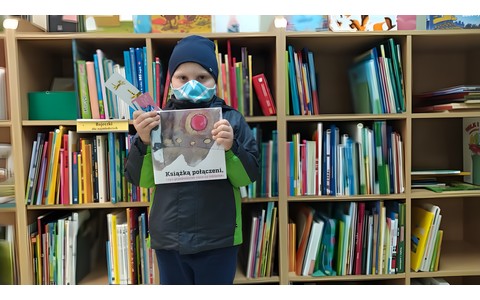 Nowy czytelnik trzymający w rękach książkę i kartę.