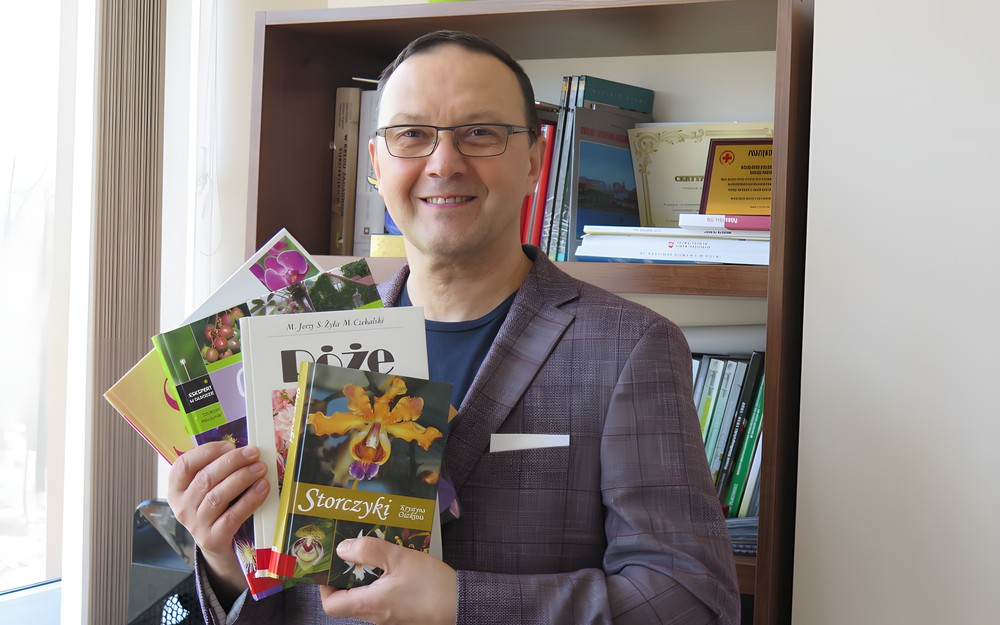 Dyrektor KBP, Dariusz Pawlikowski trzyma w rękach książki o kwiatach