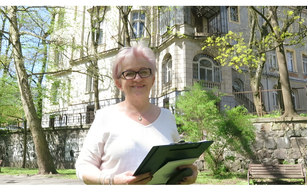 Na zdjęciu: Iwona Sławińska na tle budynku dawnej Rejencji Koszalińskiej.