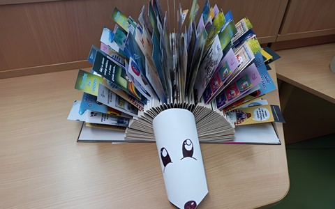 Na stole leży jeżyk z kolorowymi zakładkami do książek.