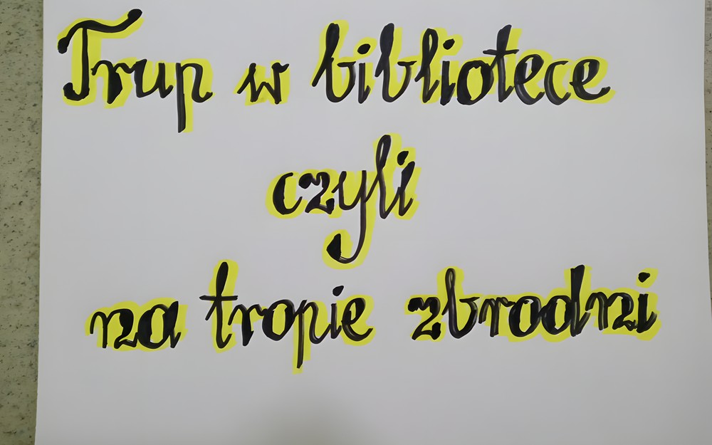 Biała kartka z czarno-żółtym napisem: Trup w bibliotece, czyli na tropie zbrodni.